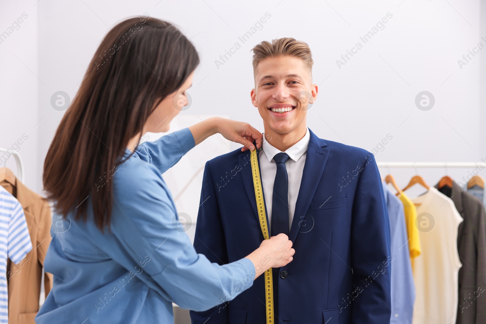 Tailor measuring jacket on man in atelier Photo of Tailor measuring jacket on man in atelier