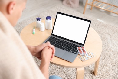 Photo of Man having online consultation with doctor via laptop at home, above view