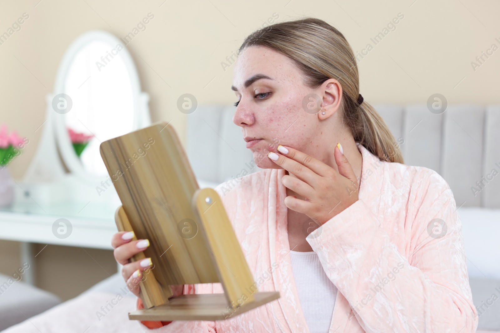 Woman with acne problem looking in mirror at home Photo of Woman with acne problem looking in mirror at home