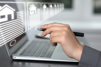 Image of Real estate agent choosing house on virtual screen above laptop, closeup