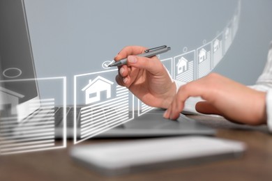 Image of Real estate agent choosing house on virtual screen above laptop, closeup