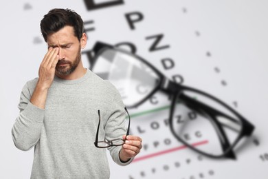 Image of Man with eyesight problems, glasses and vision test chart