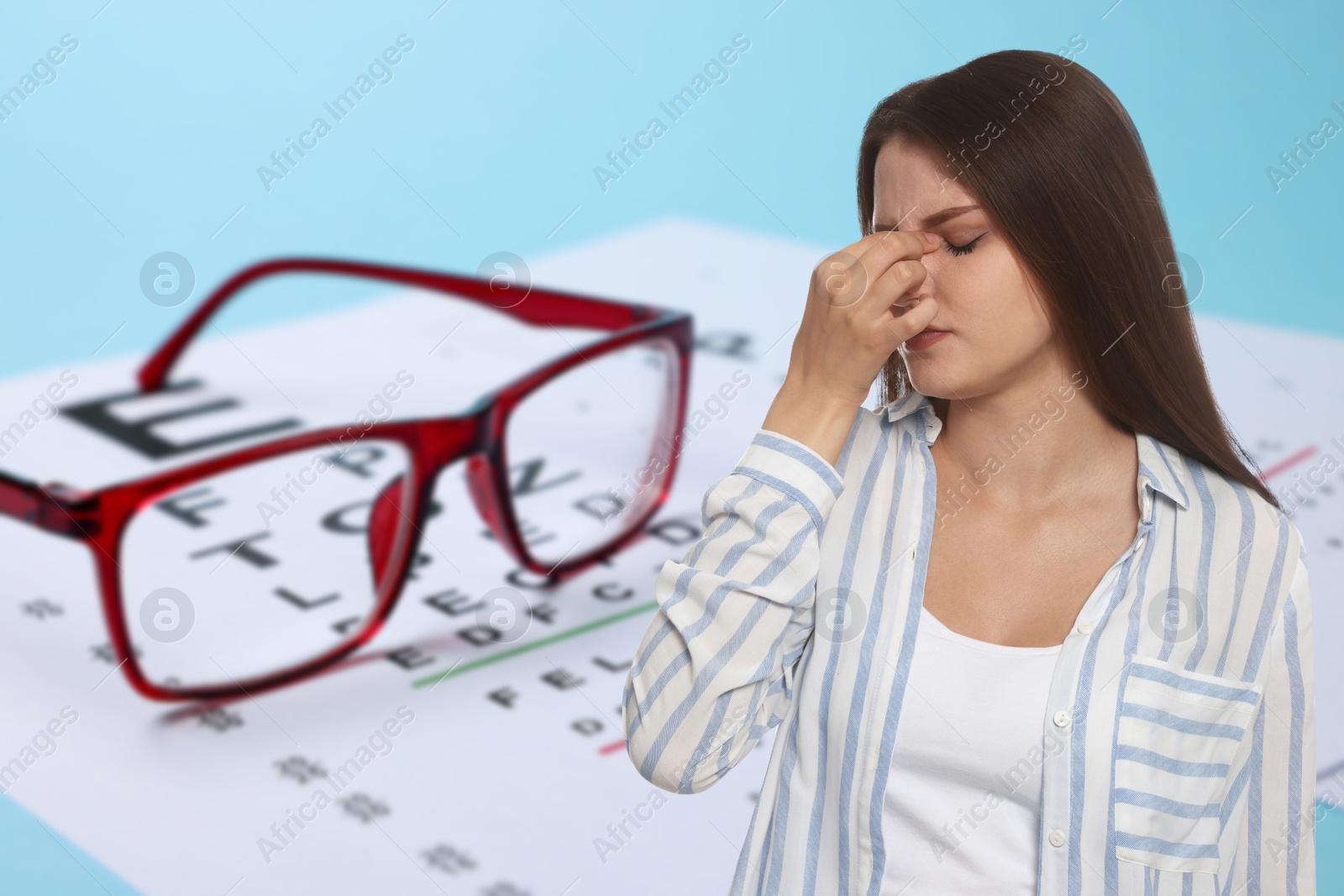 Image of Woman with eyesight problems, glasses and vision test chart on light blue background