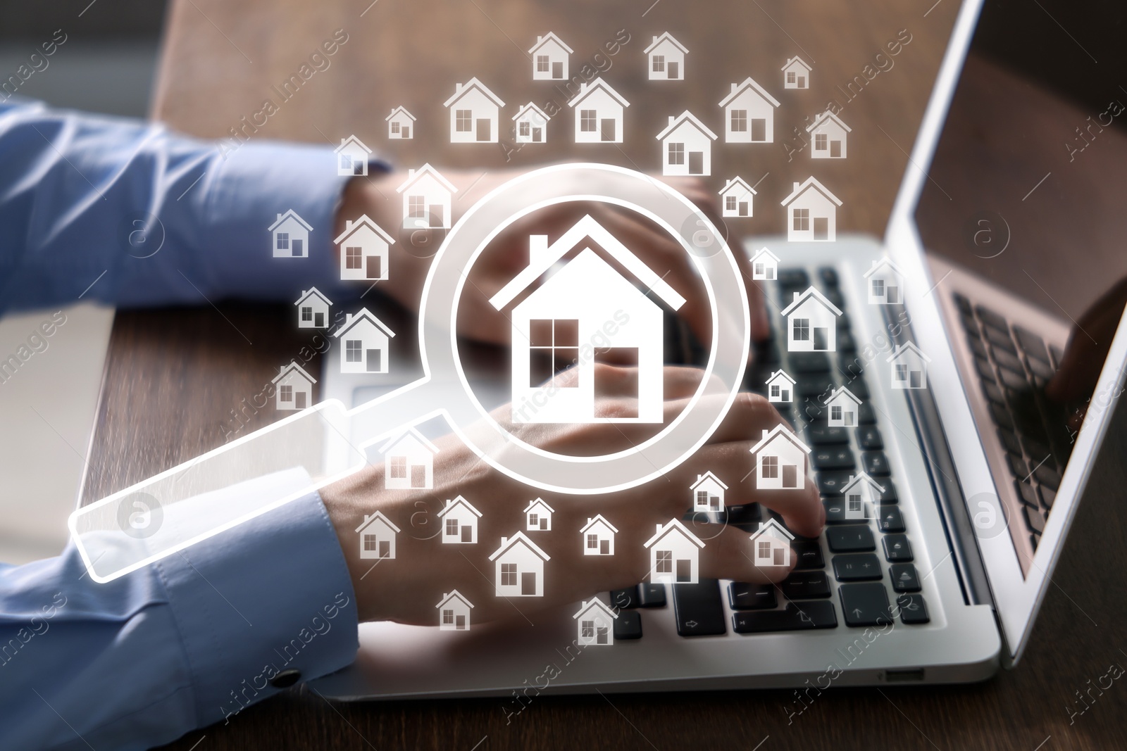 Real estate agent using laptop at table, closeup. House and magnifying glass icons on virtual screen Image of Real estate agent using laptop at table, closeup. House and magnifying glass icons on virtual screen