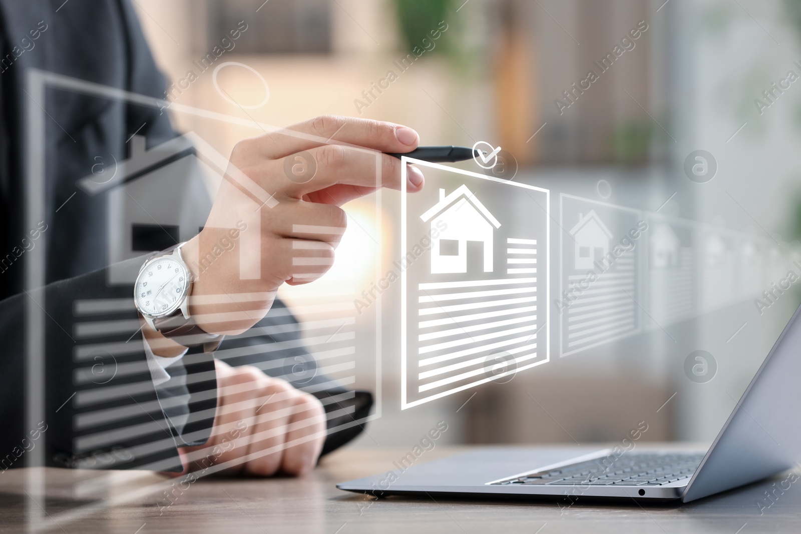 Real estate agent choosing house on virtual screen above laptop, closeup Image of Real estate agent choosing house on virtual screen above laptop, closeup