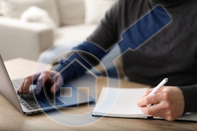 Image of Real estate agent using laptop and writing in notebook at table, closeup. Magnifying glass with house icon on virtual screen