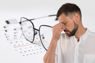 Image of Man with eyesight problems, glasses and vision test chart