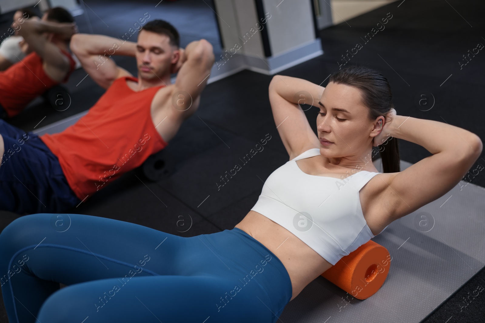Young woman exercising on fitness mat with professional personal trainer in gym Photo of Young woman exercising on fitness mat with professional personal trainer in gym
