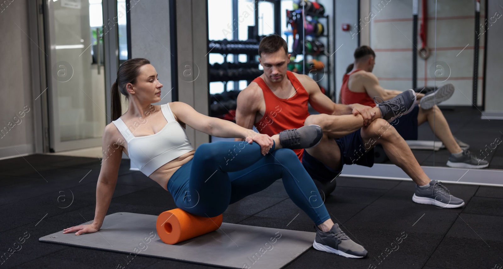 Young woman exercising on fitness mat with professional personal trainer in gym Photo of Young woman exercising on fitness mat with professional personal trainer in gym