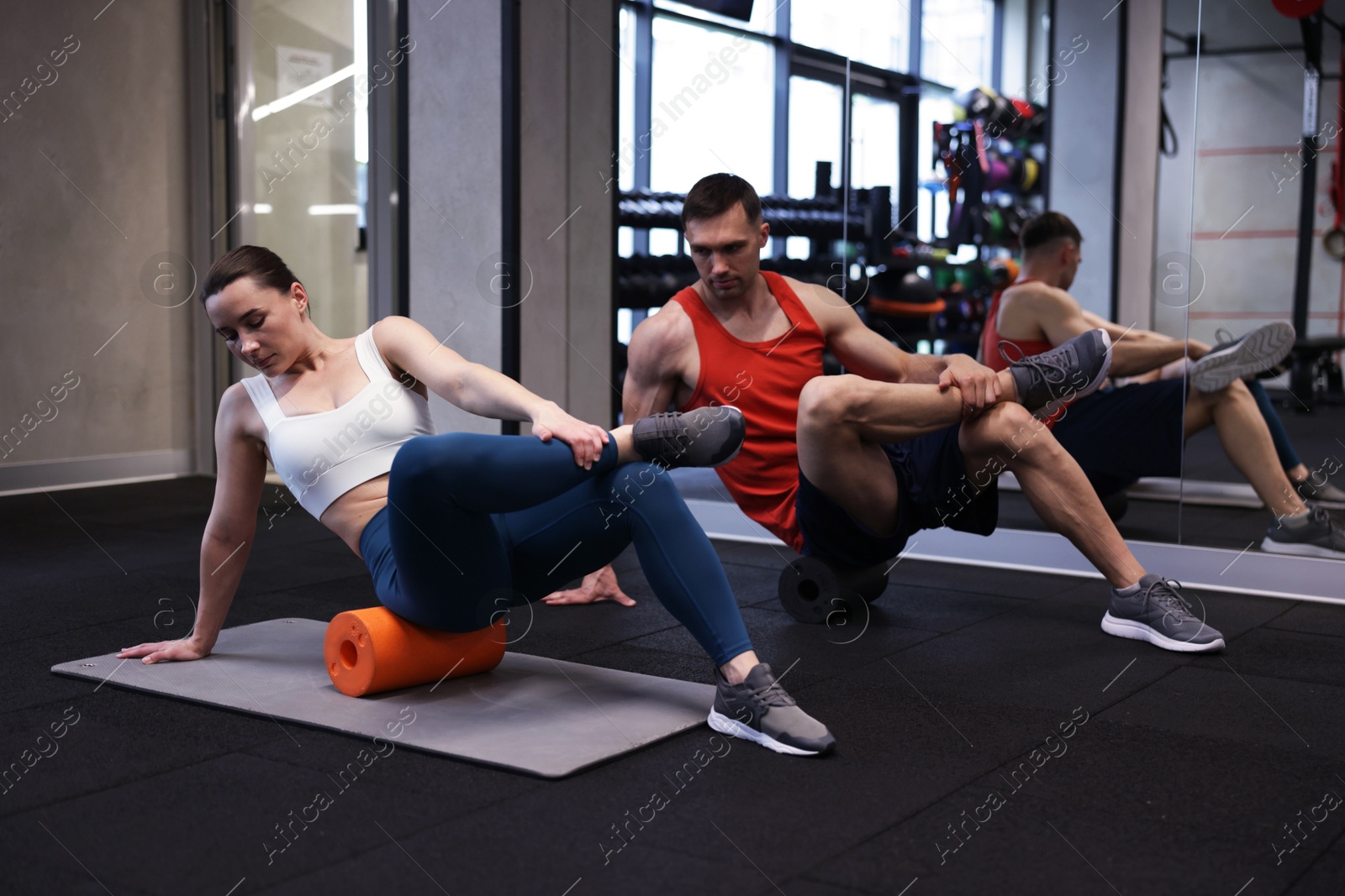 Young woman exercising on fitness mat with professional personal trainer in gym Photo of Young woman exercising on fitness mat with professional personal trainer in gym