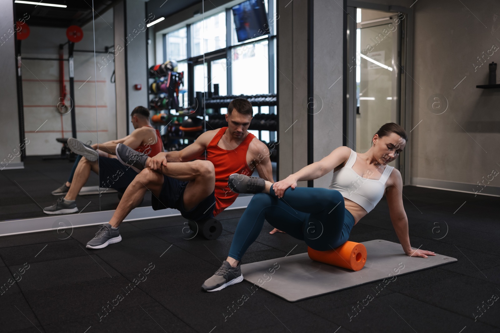 Young woman exercising on fitness mat with professional personal trainer in gym Photo of Young woman exercising on fitness mat with professional personal trainer in gym