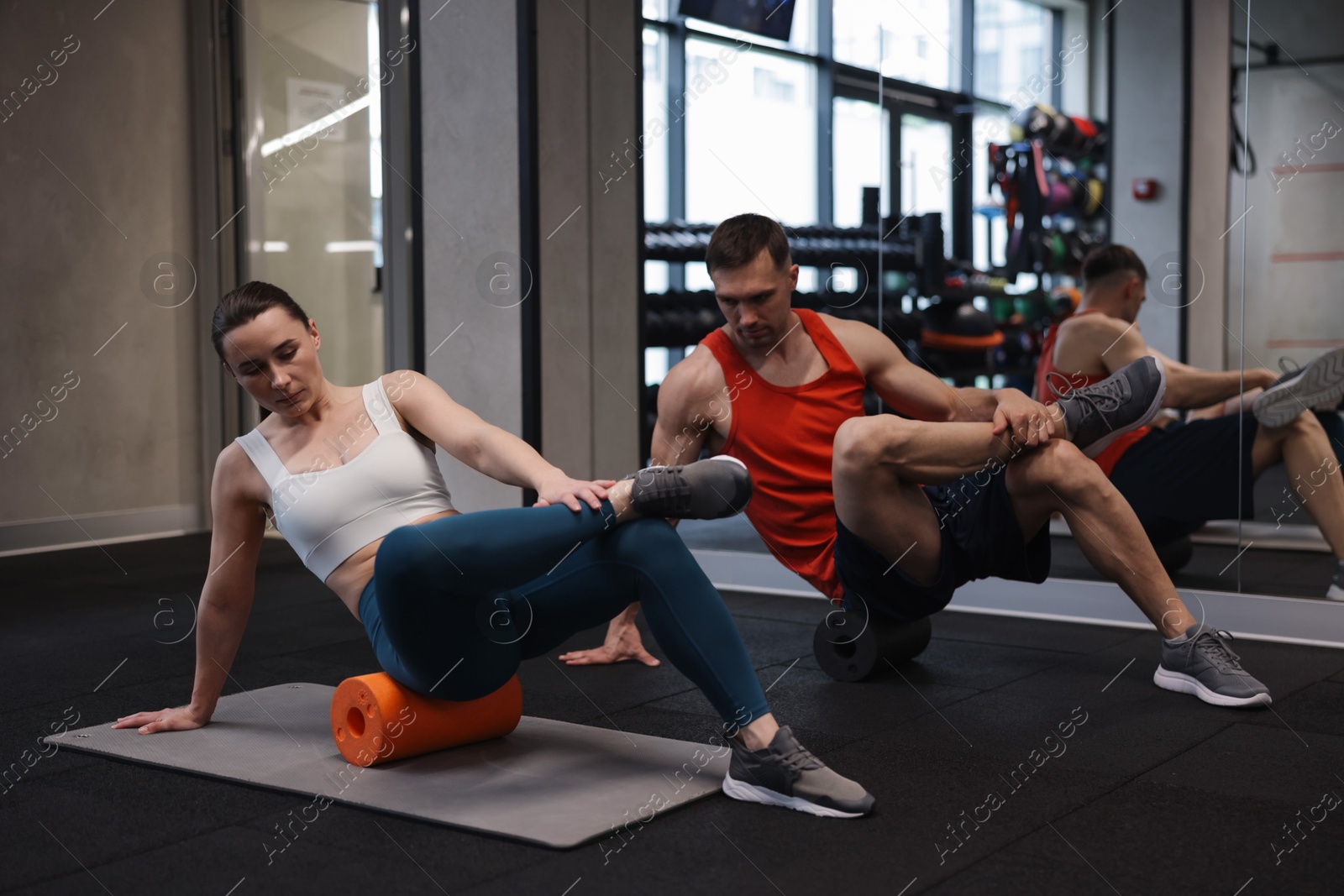 Young woman exercising on fitness mat with professional personal trainer in gym Photo of Young woman exercising on fitness mat with professional personal trainer in gym