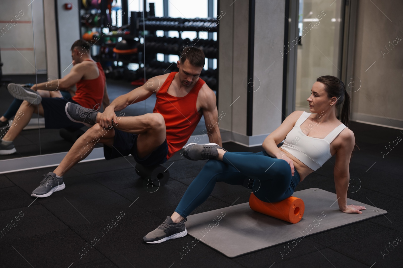 Young woman exercising on fitness mat with professional personal trainer in gym Photo of Young woman exercising on fitness mat with professional personal trainer in gym