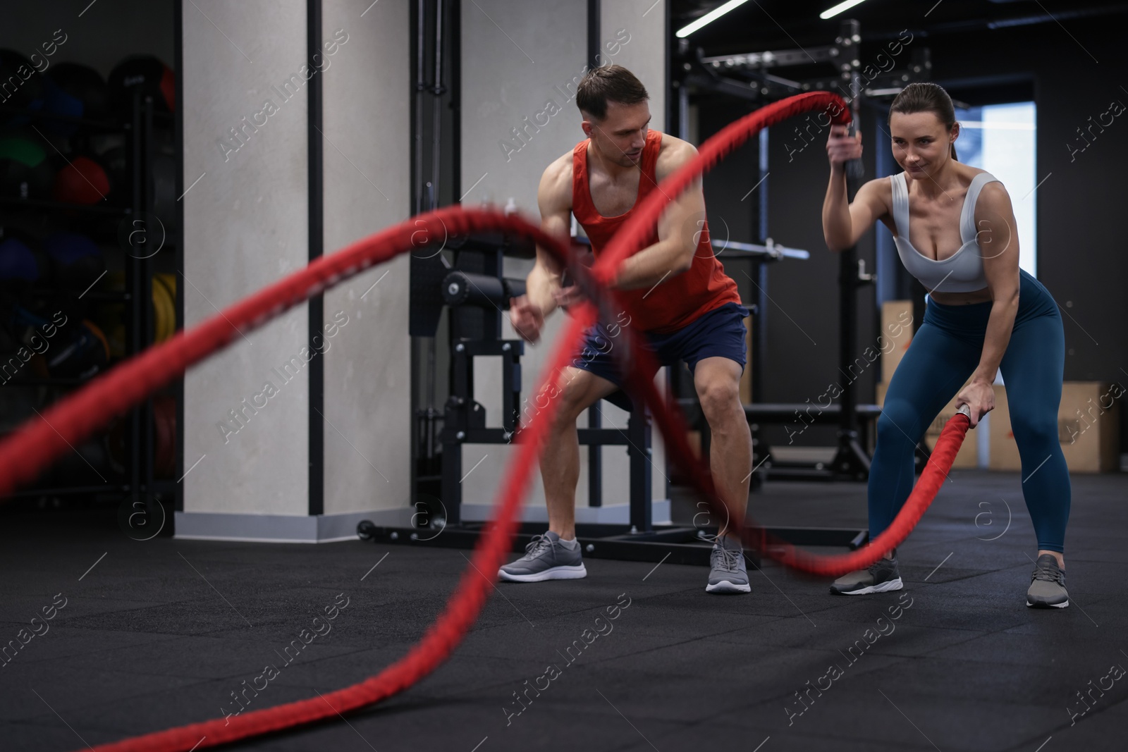 Young woman exercising with battle ropes and professional personal trainer in gym Photo of Young woman exercising with battle ropes and professional personal trainer in gym