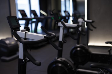 Photo of Many modern professional bicycle machines in gym, closeup