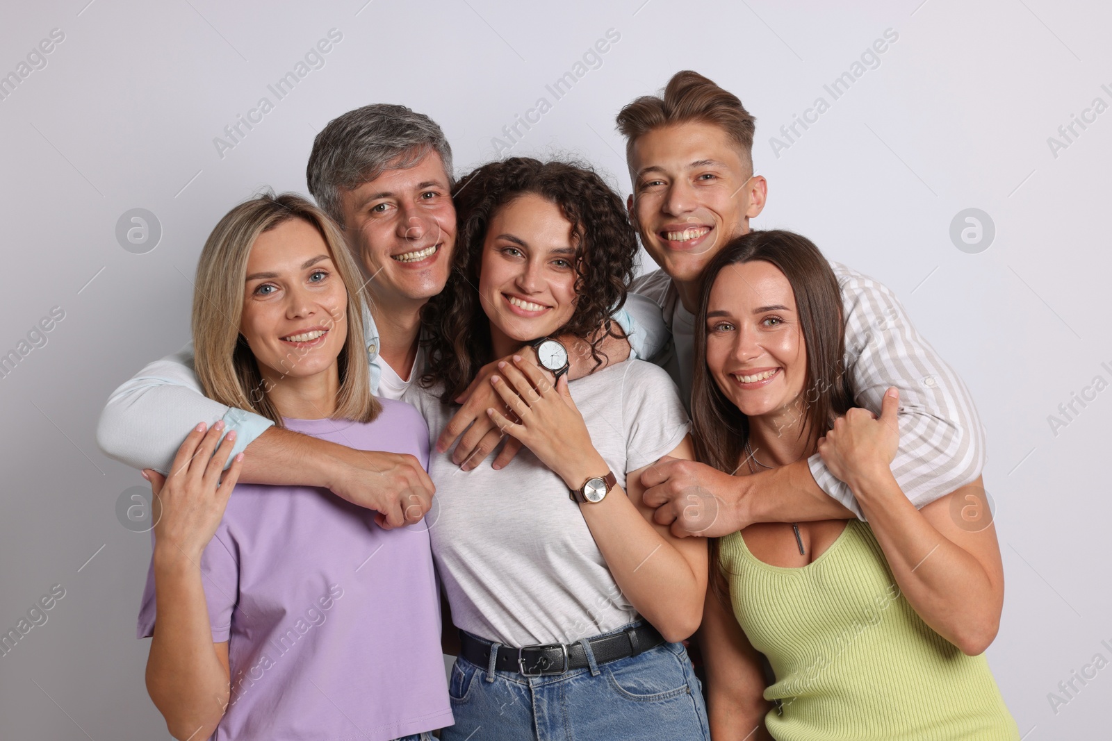 Portrait of happy friends hugging on grey background Photo of Portrait of happy friends hugging on grey background