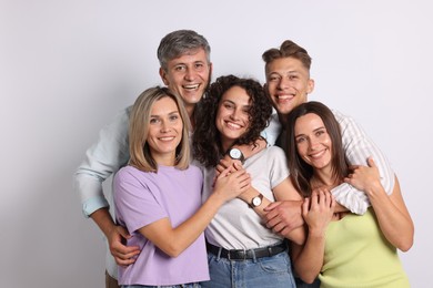 Photo of Portrait of happy friends hugging on grey background
