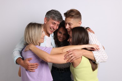 Photo of Group of happy friends hugging on grey background