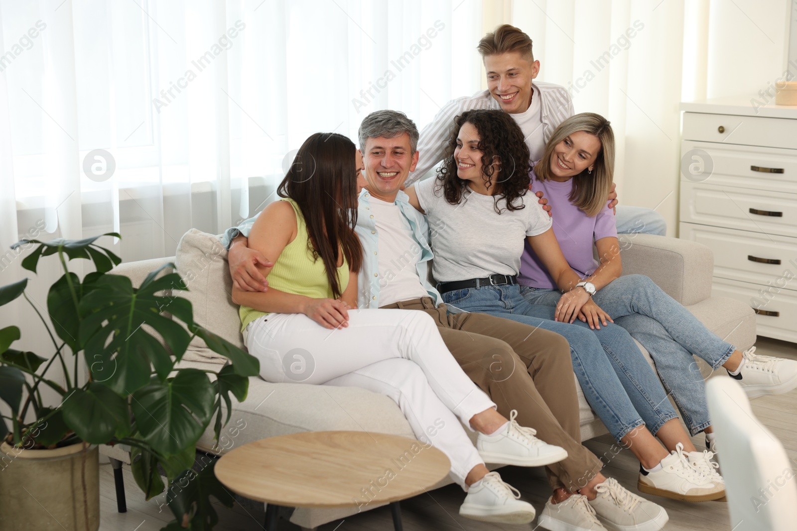 Happy friends hugging and having fun on sofa at home Photo of Happy friends hugging and having fun on sofa at home