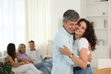 Photo of Happy friends hugging at home, selective focus