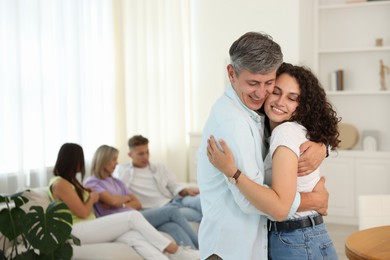 Photo of Happy friends hugging at home, selective focus