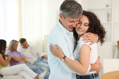 Photo of Happy friends hugging at home, selective focus