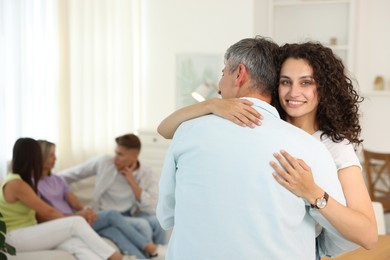 Photo of Happy friends hugging at home, selective focus
