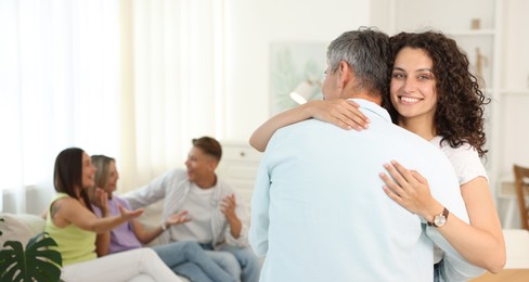 Photo of Happy friends hugging at home, selective focus