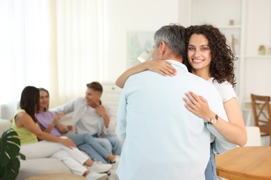 Photo of Happy friends hugging at home, selective focus
