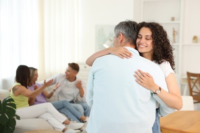 Photo of Happy friends hugging at home, selective focus