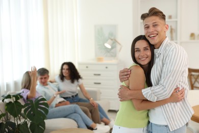 Photo of Happy friends hugging at home, selective focus