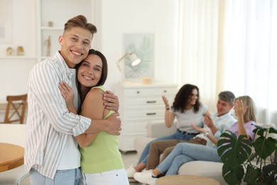 Photo of Happy friends hugging at home, selective focus