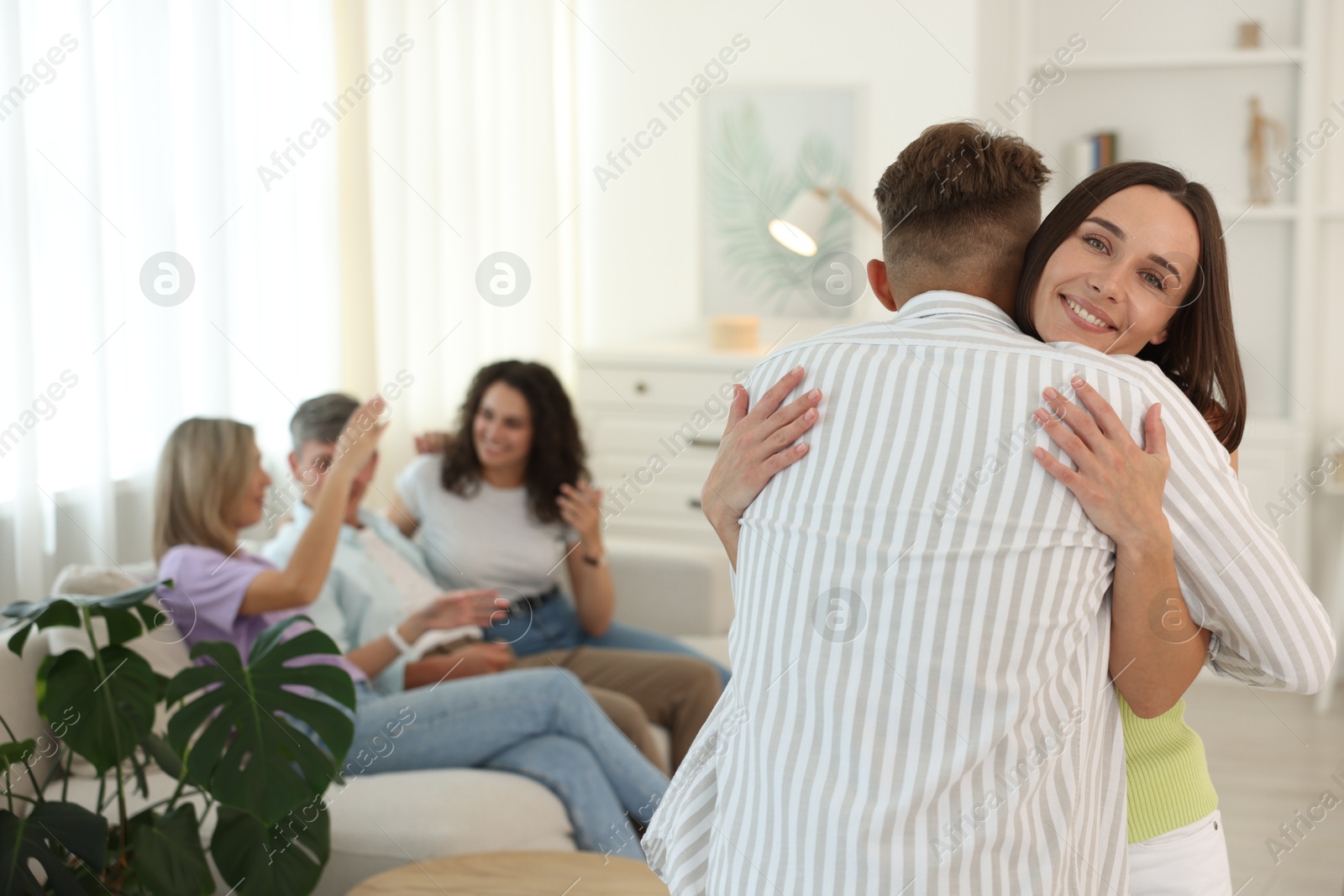 Photo of Happy friends hugging at home, selective focus