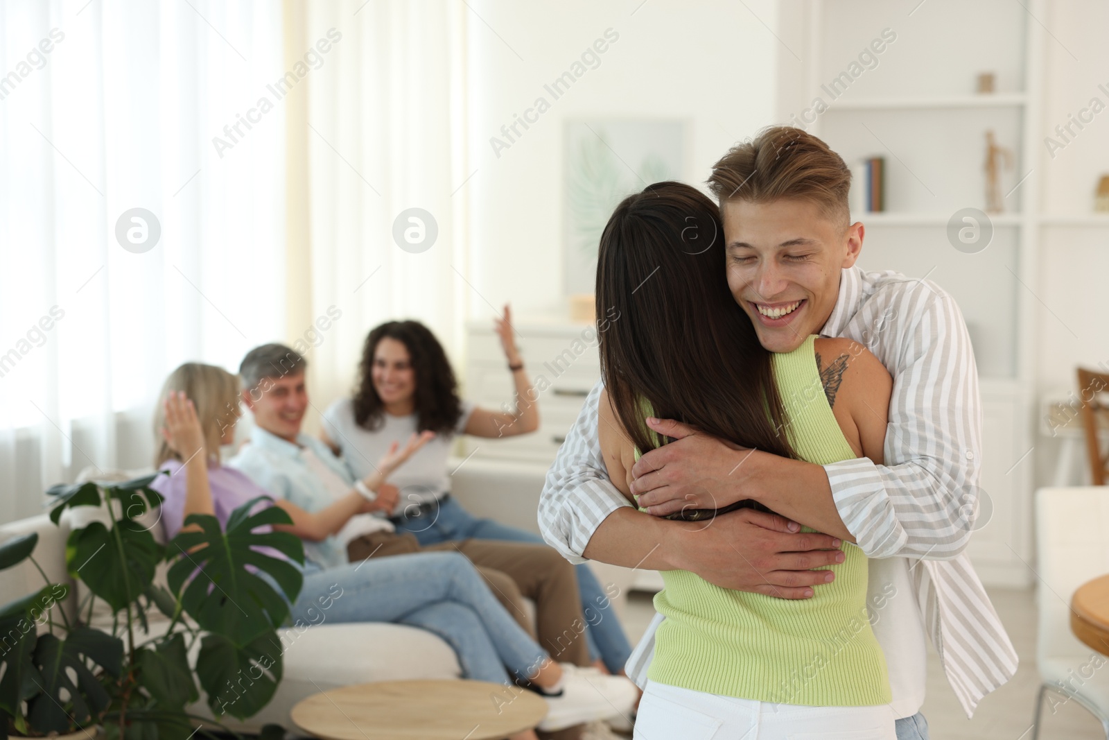 Photo of Happy friends hugging at home, selective focus