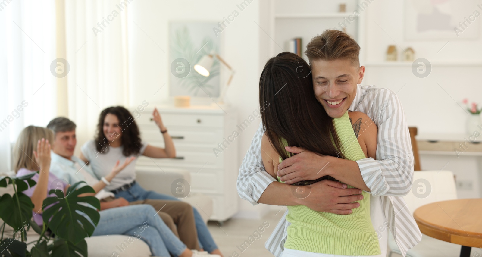 Photo of Happy friends hugging at home, selective focus