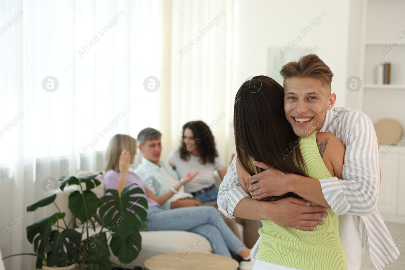 Photo of Happy friends hugging at home, selective focus
