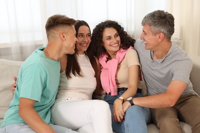 Photo of Happy friends hugging and having fun on sofa at home