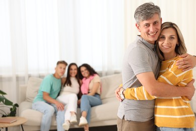 Photo of Happy friends hugging at home, selective focus