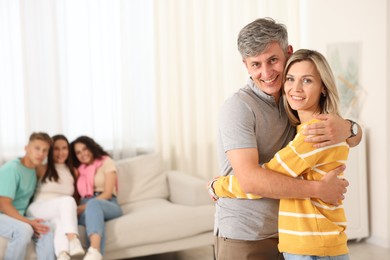 Photo of Happy friends hugging at home, selective focus
