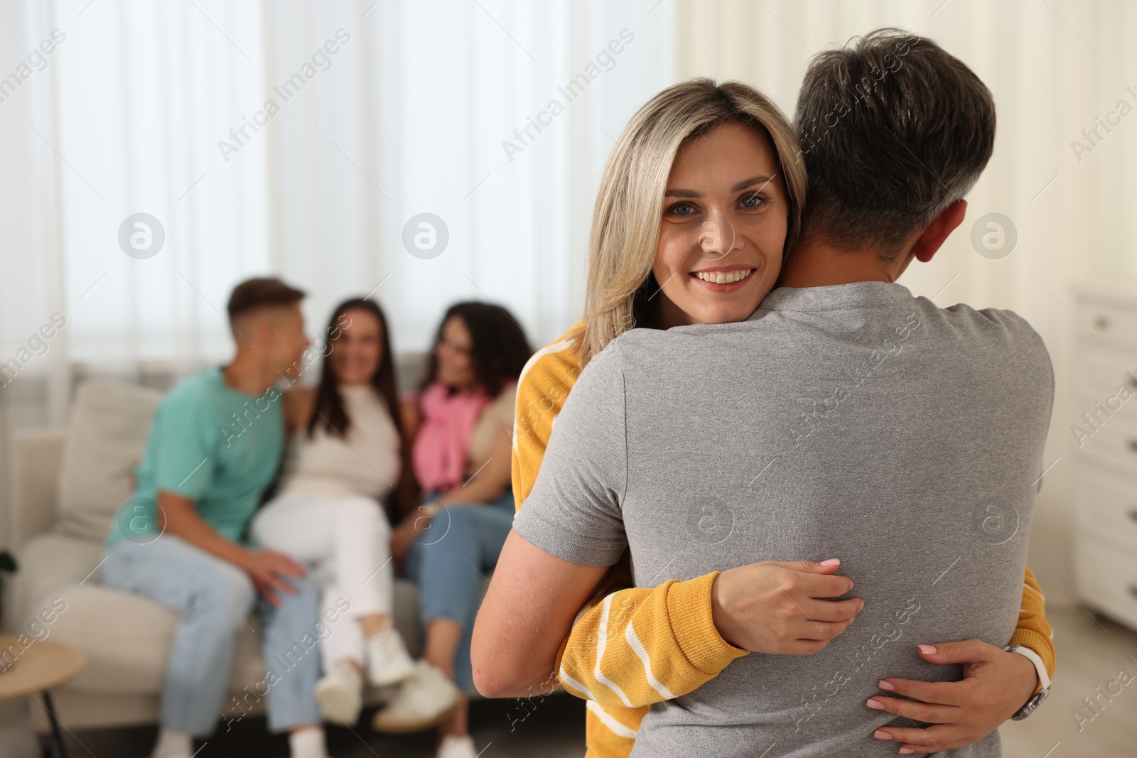 Photo of Happy friends hugging at home, selective focus