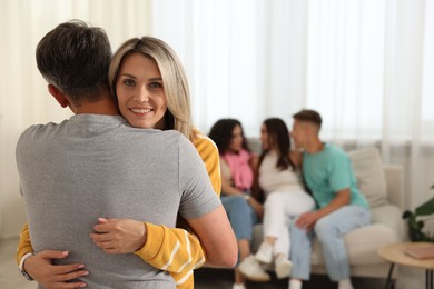 Photo of Happy friends hugging at home, selective focus
