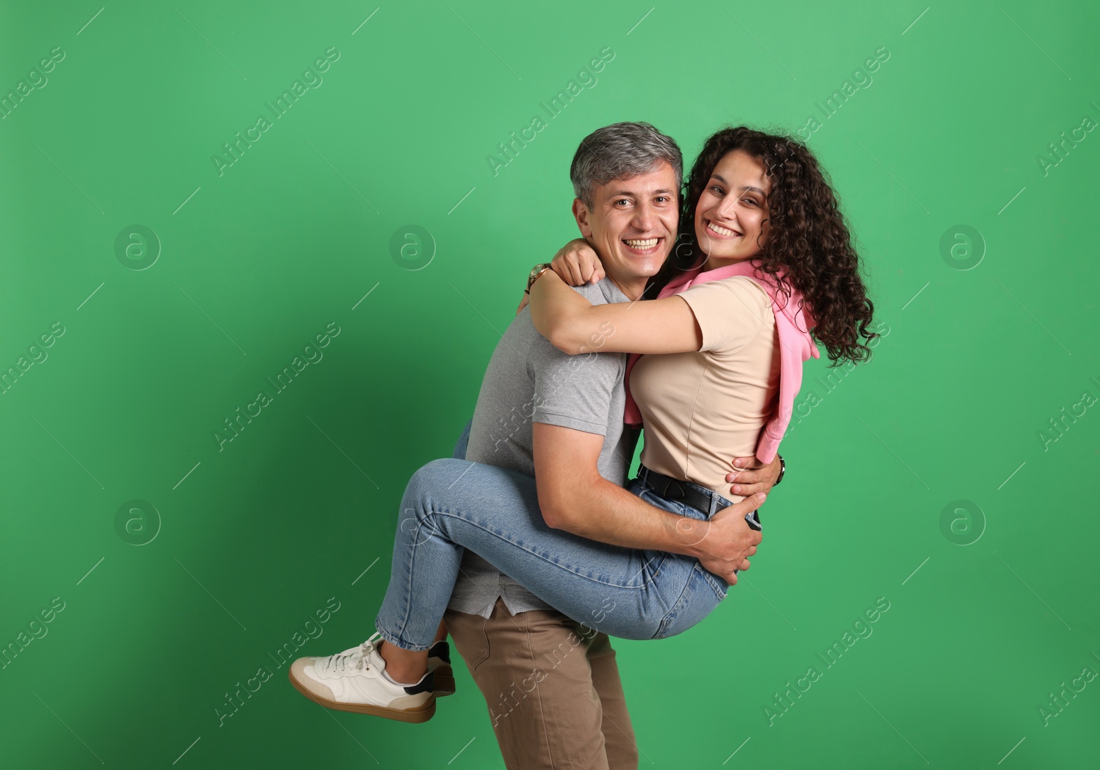 Photo of Happy friends hugging each other on green background