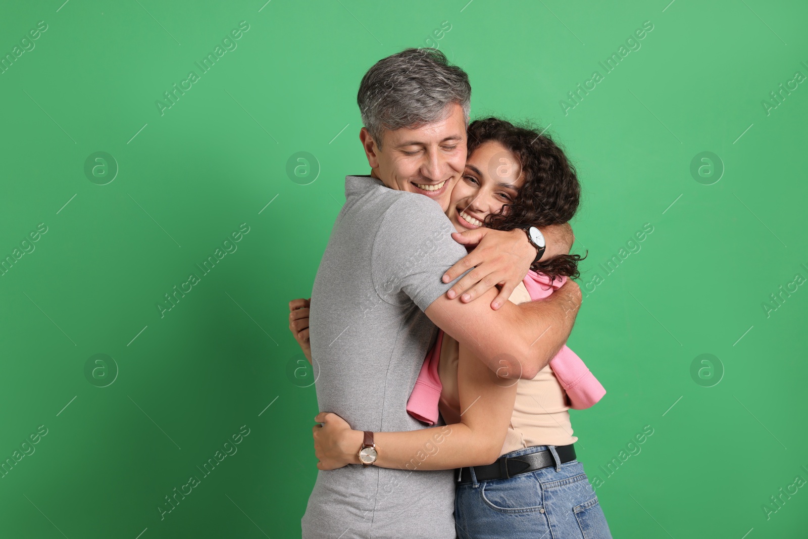 Photo of Happy friends hugging each other on green background