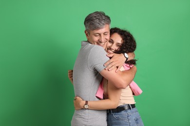 Photo of Happy friends hugging each other on green background
