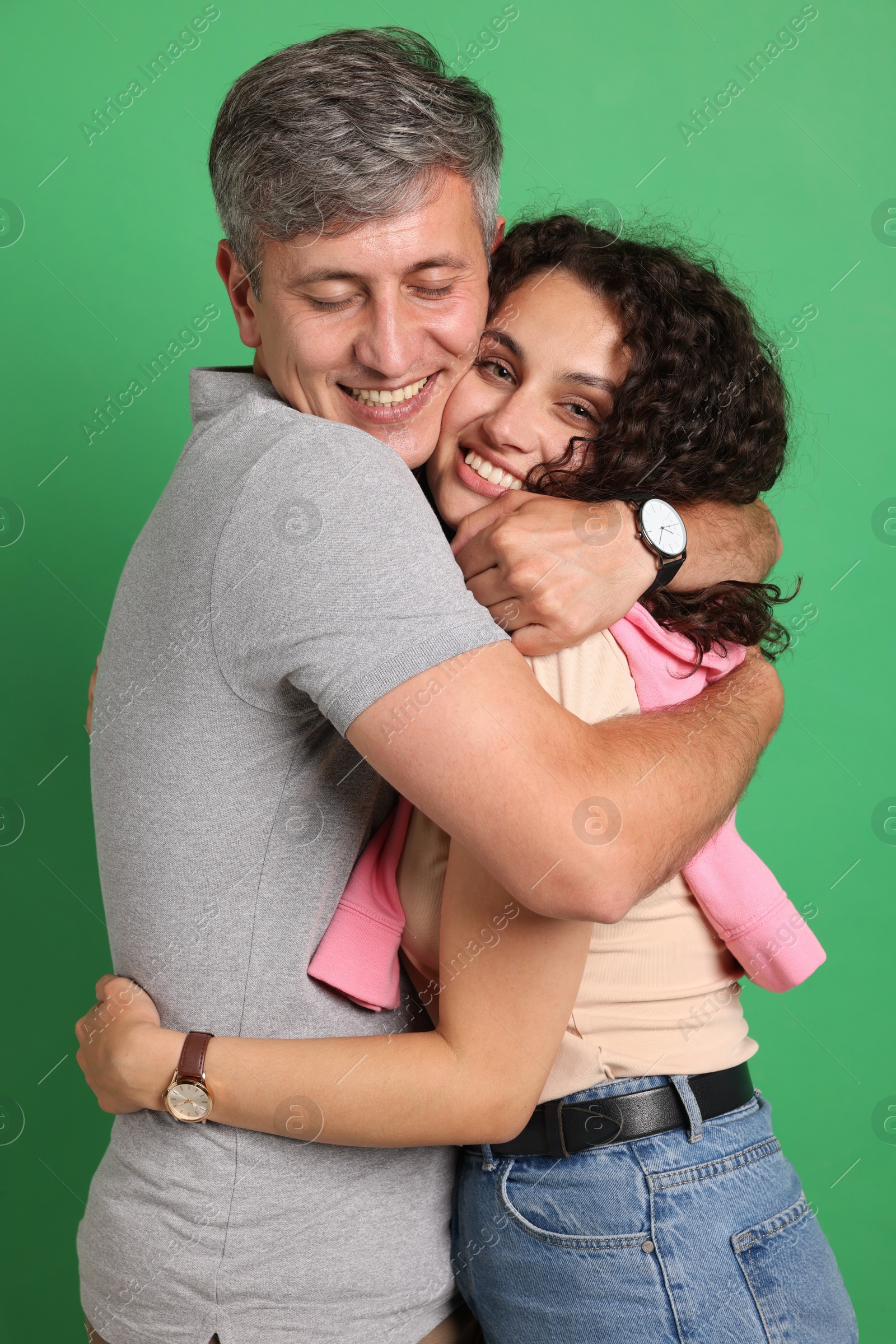 Photo of Happy friends hugging each other on green background