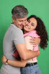 Photo of Happy friends hugging each other on green background