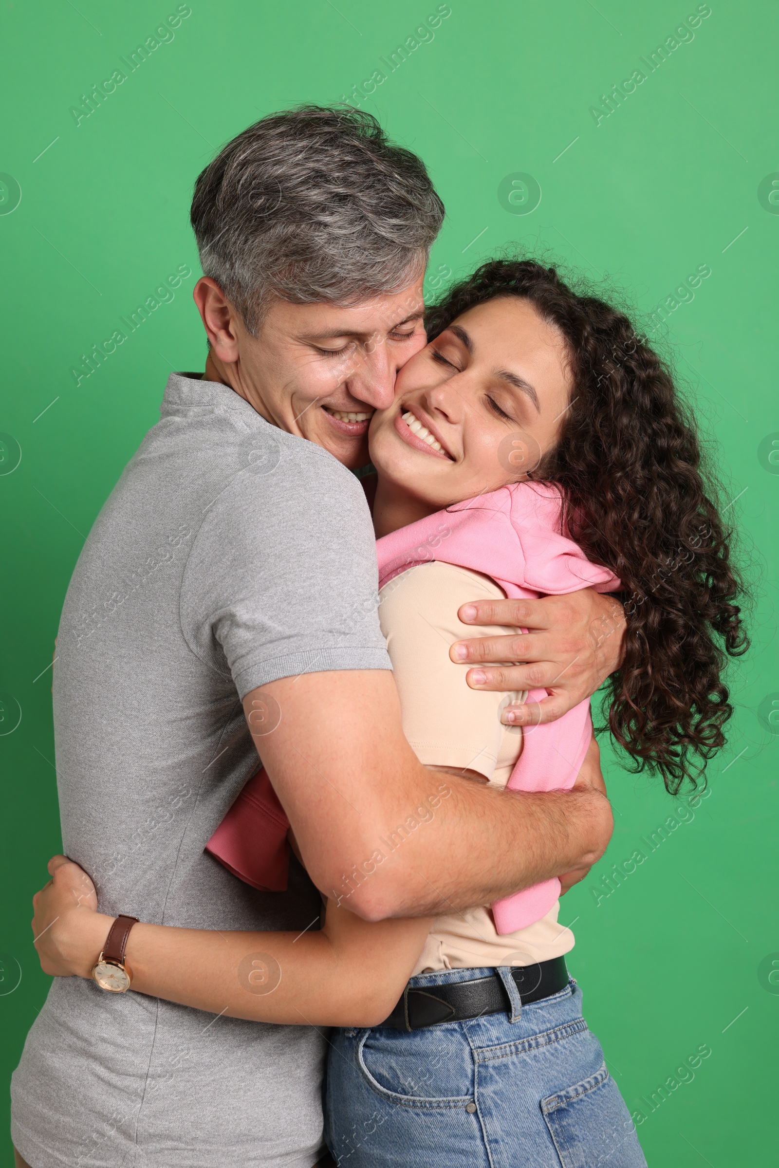 Photo of Happy friends hugging each other on green background
