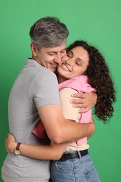 Photo of Happy friends hugging each other on green background