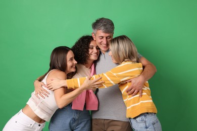 Photo of Happy friends hugging each other on green background