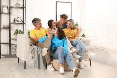 Photo of Happy friends hugging on sofa at home